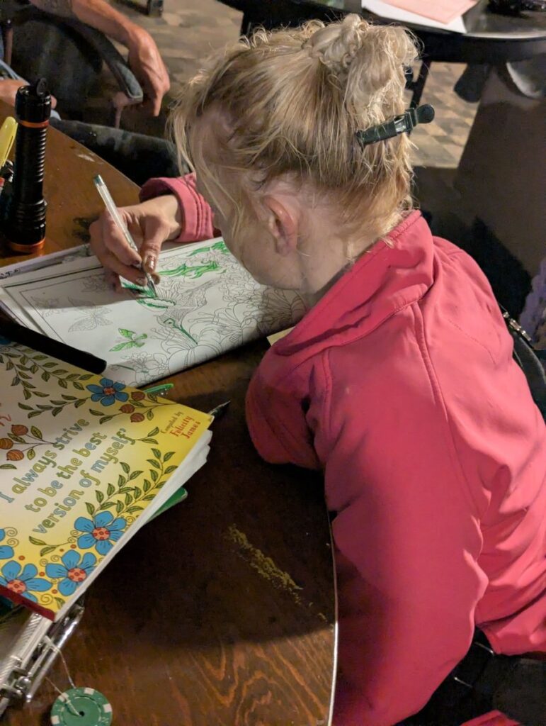A participant works on a detailed illustration at the table