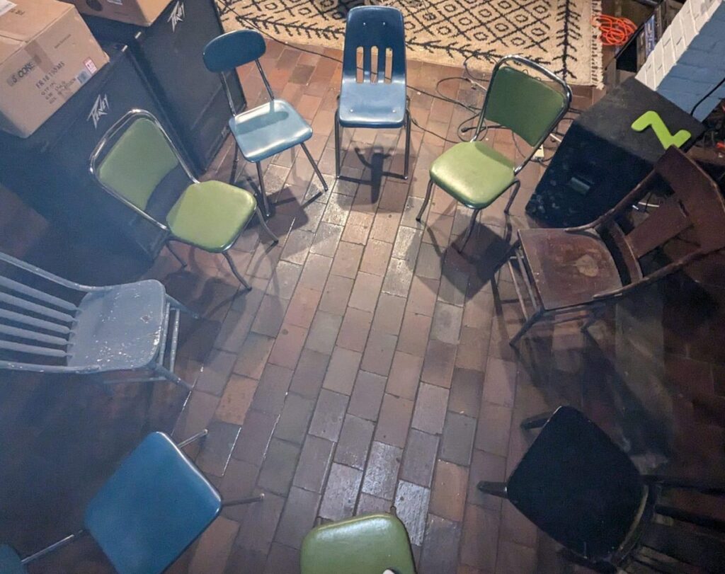 A circle of chairs set up for a peer-led creative session