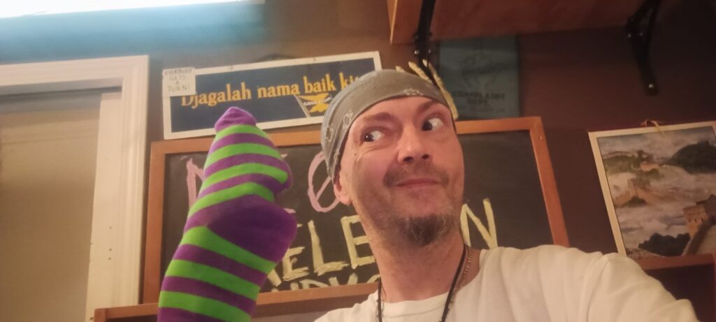 Ryan Scanlon holds up a striped sock-puppet prototype of Mr. Buttons, Second Chance Village's puppet character in development