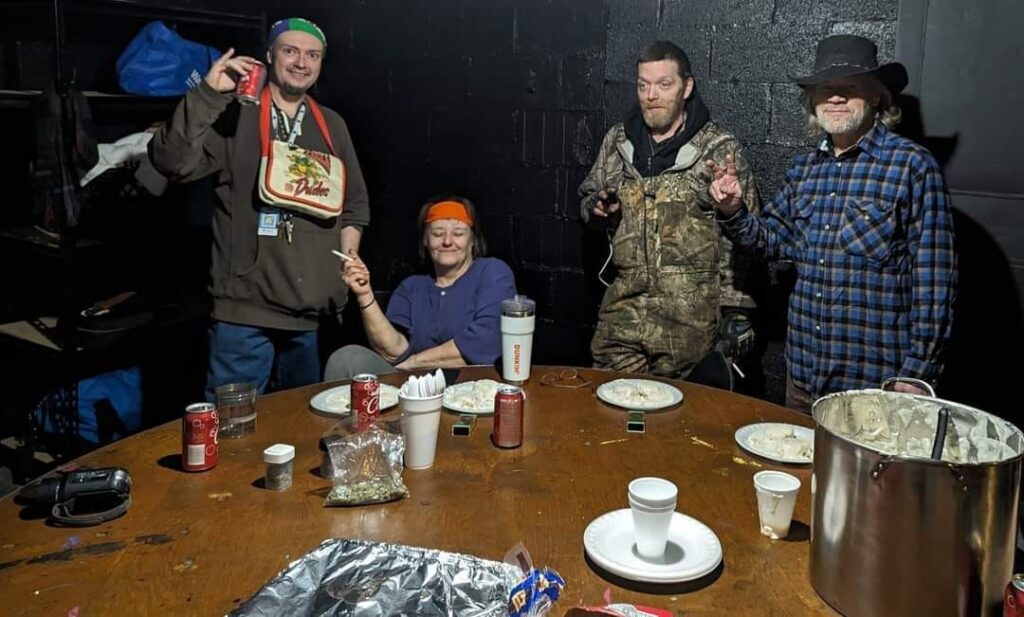 Members gather and talk around a table during a peer support session